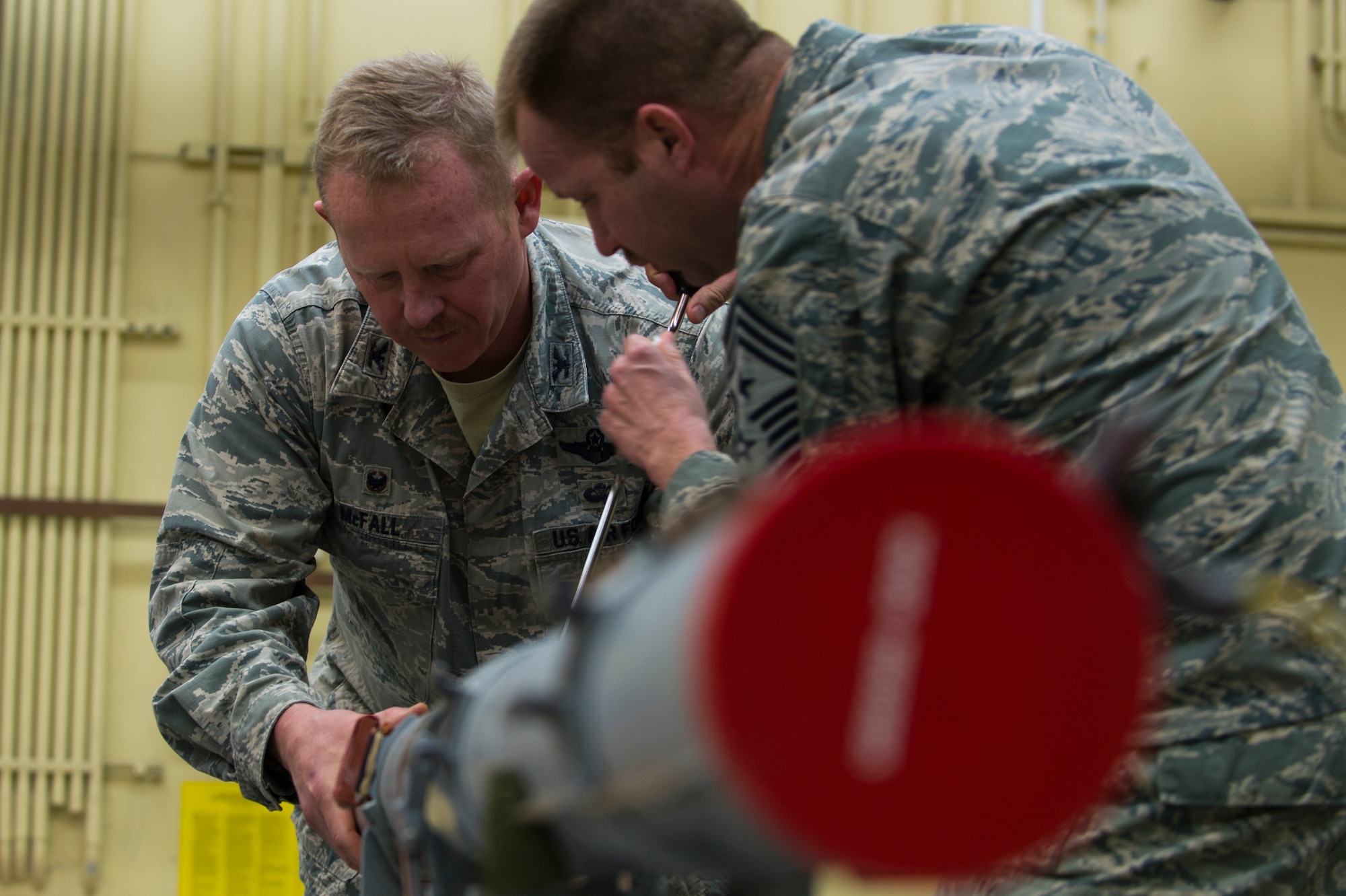 U.S. Air Force Col. Joseph McFall, 52nd Fighter Wing command and Chief Master Sgt. Edwin Ludwigsen, 52nd FW command chief, build an Air Intercept Missile 9 during a Saber leadership “out and about” event at Spandgdahlem Air Base, Germany, March 27, 2017. The 52nd Maintenance Squadron munitions section provides all explosives to the 52nd FW to include missiles, guided bombs, 20 mm gun ammo, chaff/flare, countermeasures and practice bomb dummy unit 33 bombs.(U.S. Air Force photo by Senior Airman Dawn M. Weber)