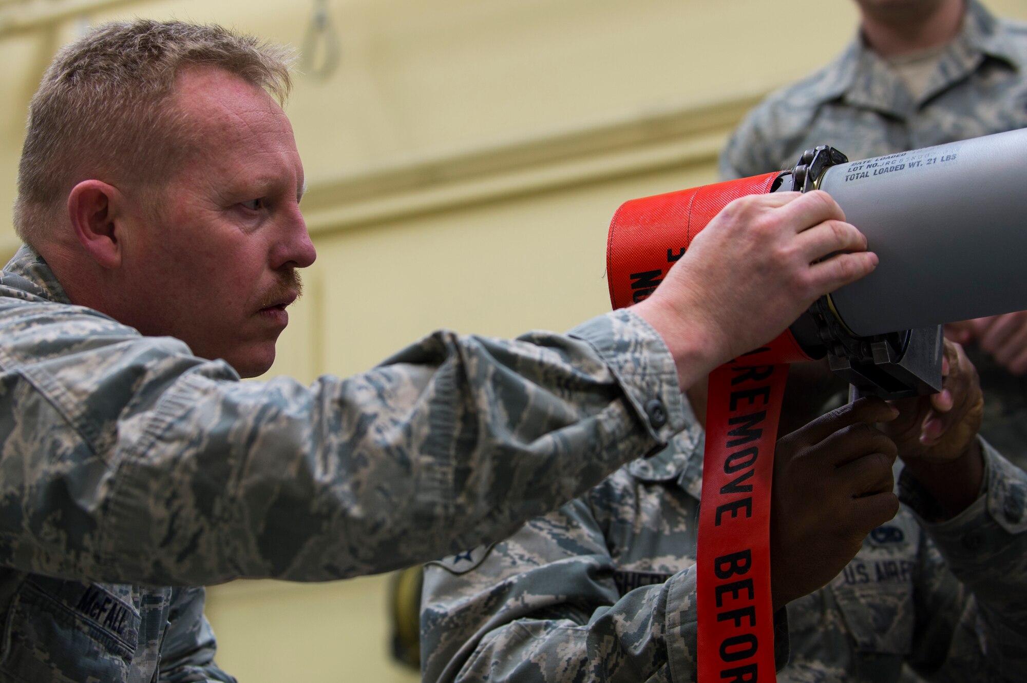 U.S. Air Force Col. Joseph McFall, 52nd Fighter Wing commander, secures components to an Air Intercept Missile 9 at during a Saber leadership “out and about” event Spangdahlem Air Base, Germany, March 27, 2017. The leadership team visited the 52nd Maintenance Squadron munitions section to learn the basics of munitions building and how pilots use them during flight. (U.S. Air Force photo by Senior Airman Dawn M. Weber)