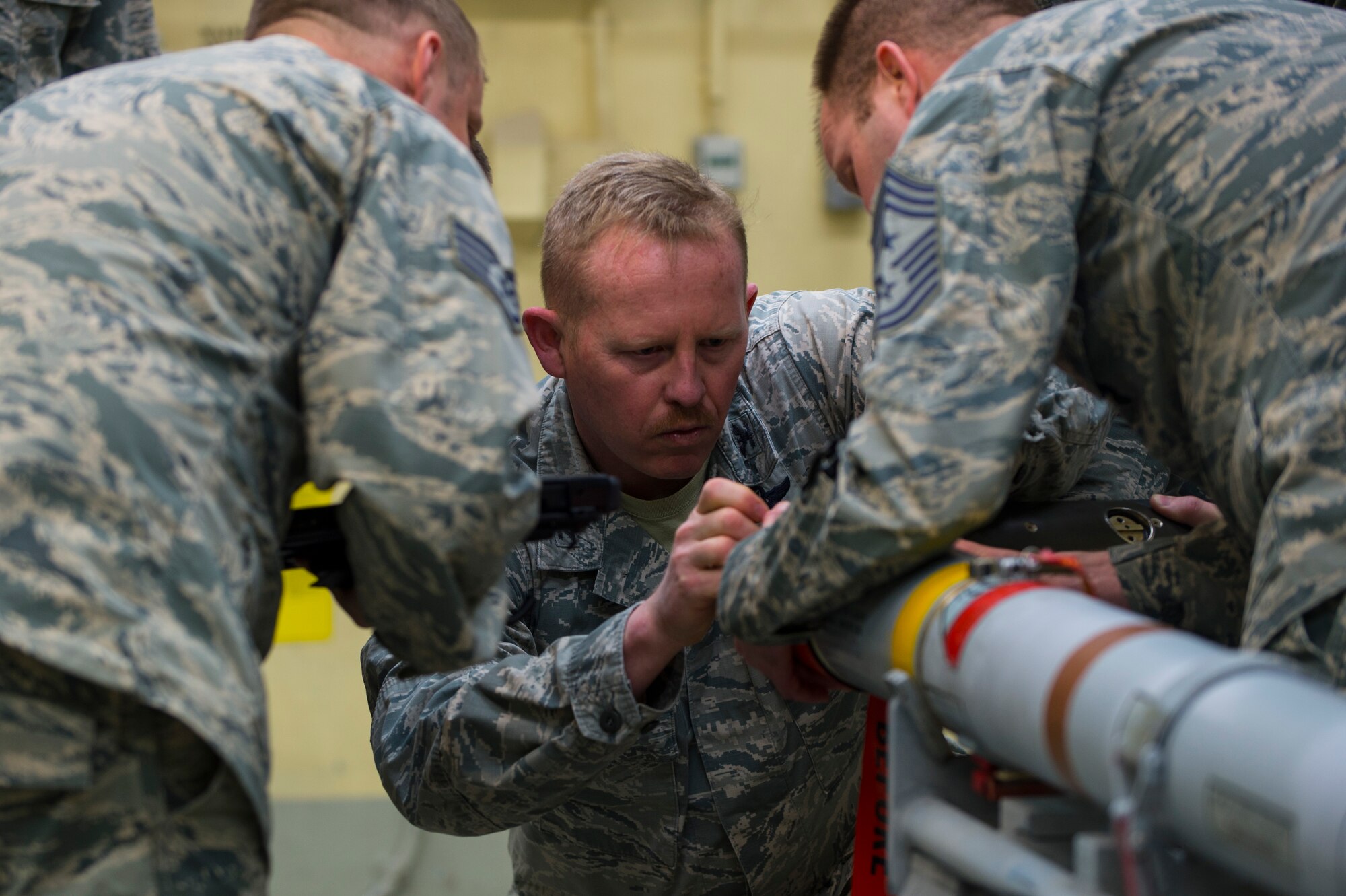 U.S. Air Force Col. Joseph McFall, 52nd Fighter Wing commander, assisted by Chief Master Sgt. Edwin Ludwigsen, 52nd FW command chief, builds an Air Intercept Missile 9 during a Saber leadership “out and about” event at Spangdahlem Air Base, Germany, March 27, 2017. Wing leadership learned the full spectrum of munitions building to include, testing, inspection, configuration, maintenance, and transportation. (U.S. Air Force photo by Senior Airman Dawn M. Weber)
