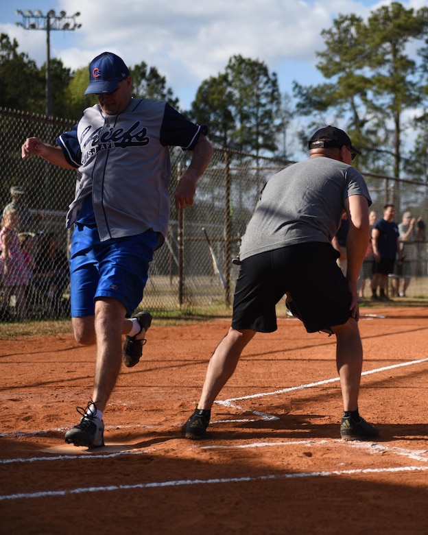 Todd Cole, Chiefs left fielder, steps on home plate scoring the first run of the Chiefs victory over the Eagles at the Joint Base Charleston softball fields March 24, 2017. The game helps build comradery between prominent Joint Base Charleston senior enlisted and field grade officers. Team Chiefs, comprised of chief master sergeants, outscored team Eagles, comprised of field grade officers, 27-13.
