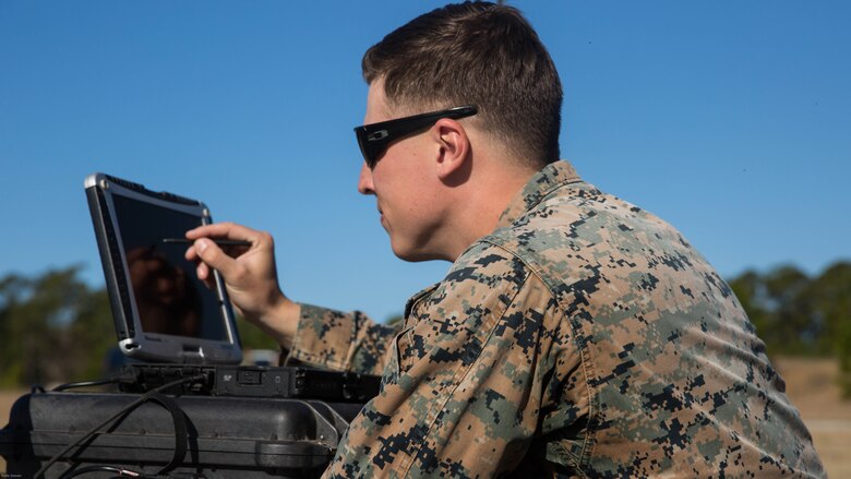 Sgt. Kyle Phillips configures computer equipment to ensure communications and controls connected to a Raven small unmanned aircraft system are working properly at Marine Corps Base Camp Lejeune, N.C., March 27, 2017. Marines conducted aerial training exercises at Tactical Landing Zone Dove to demonstrate the capabilities and build familiarization with the SUAS. Phillips is an intelligence specialist with 2nd Battalion, 8th Marine Regiment. 