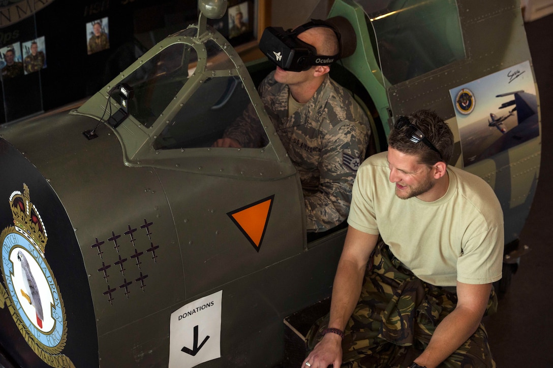 Air Force Staff Sgt. Geremy Stovall, left, listens to instructions from Netherlands air force Sgt. 1st Class Robbert Kwantes while piloting their Spitfire flight simulator during a social event at Leeuwarden Air Base in the Netherlands, March 28, 2017. Stovall is an aerospace reclamation technician assigned to the 159th Maintenance Squadron. Kwantes is a crew chief is assigned to the 322nd Squadron. Air Force photo by Staff Sgt. Jonathan Snyder 