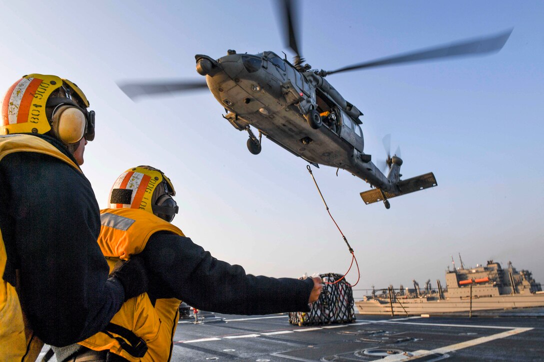Navy Petty Officer 1st Class Runsiya Richards, front, and Seaman Thomas Bade signal to an MH-60S Sea Hawk helicopter as it brings cargo from the Lewis and Clark-class dry cargo ship USNS Charles Drew during a vertical replenishment-at-sea aboard Arleigh Burke-class guided-missile destroyer USS Wayne E. Meyer in the Pacific Ocean, March 27, 2017. Richards is a Boatswain’s Mate. The helicopter crew is assigned to Helicopter Sea Combat Squadron 4. Wayne E. Meyer is on a regularly scheduled Western Pacific deployment with the Carl Vinson Carrier Strike Group as part of the U.S. Pacific Fleet-led initiative to extend the command-and-control functions of U.S. 3rd Fleet into the Indo-Asia-Pacific region. Navy photo by Petty Officer 3rd Class Kelsey L. Adams