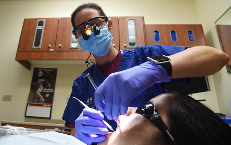Capt. (Dr.) Kim Burford, 60th Dental Squadron dentist and acting 60th Medical Group executive officer, and Marisell Efren-Wiley, 60th Dental Squadron dental technician, simulate a dental cleaning at Travis Air Force Base, Calif., March 24, 2017. Burford is organizing an upcoming humanitarian mission scheduled for May. (U.S. Air Force photo by Senior Airman Sam Salopek) 