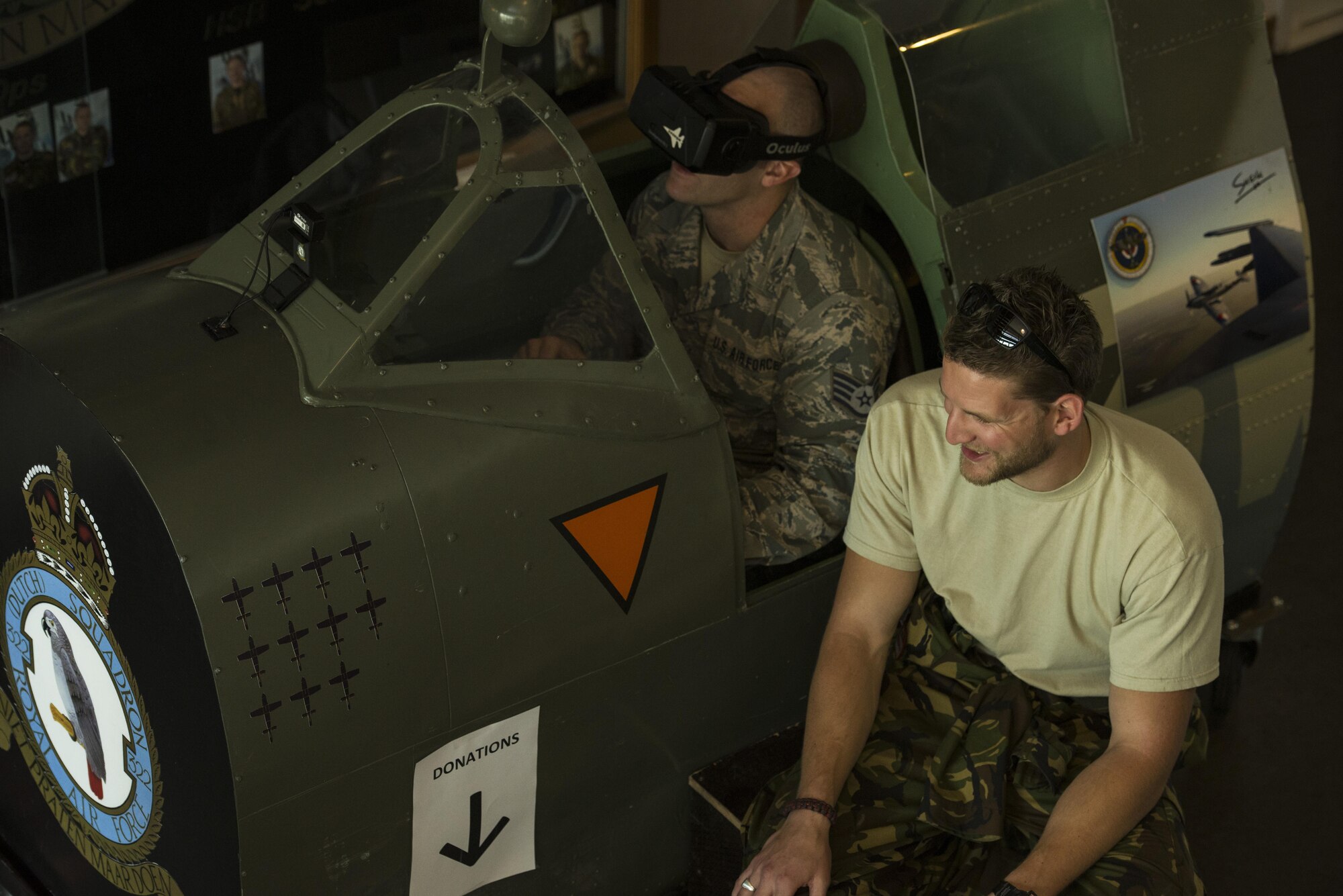 Staff Sgt. Geremy Stovall, left, 159th Maintenance Squadron aerospace reclamation technician, listens to instructions from Royal Netherlands air force Sgt. 1st Class Robbert Kwantes, right, 322nd Squadron crew chief, while piloting their Spitfire flight simulator during an ice breaker social event at Leeuwarden Air Base, Netherlands, March 28, 2017. The U.S. Air Force deployed approximately 300 Airmen along with 12 F-15Cs to Europe as a part of a Theater Security Package in support of Operation Atlantic Resolve. While in theater these aircraft will participate in Royal Netherlands Air Force-led exercise, Frisian Flag, and will then forward deploy to European NATO nations for approximately six months. (U.S. Air Force photo by Staff Sgt. Jonathan Snyder) 