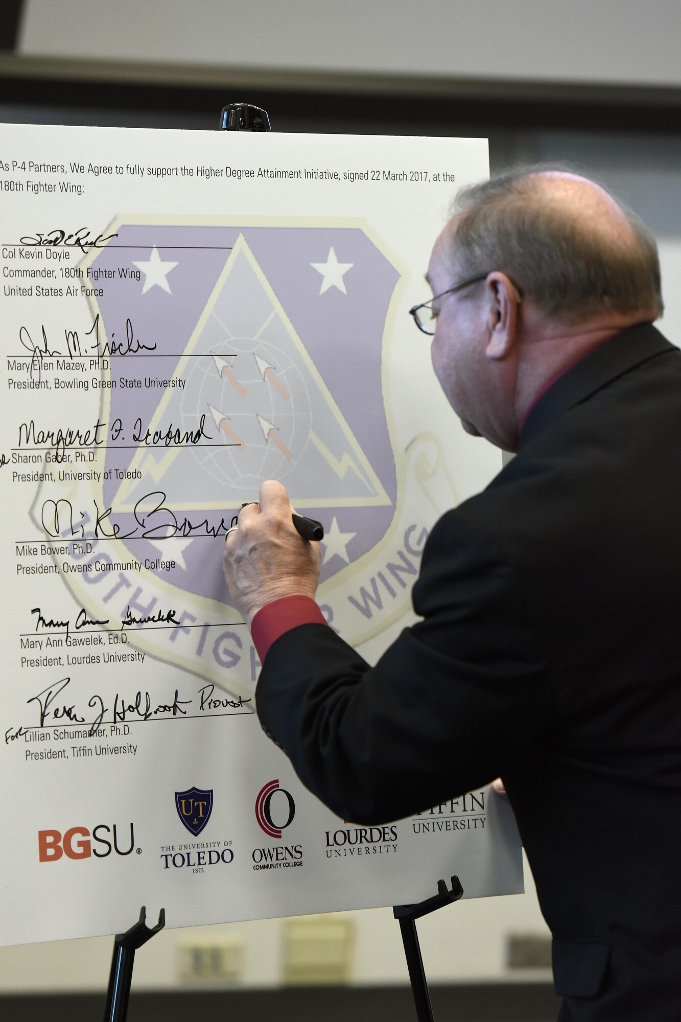 Mike Bower, president of Owens Community College, signs the Higher Degree Attainment Initiative March 22,2017 at the 180th Fighter Wing in Swanton, Ohio. The agreement between the 180FW and five local-area universities provides additional education opportunities for 180FW Airmen while providing participating colleges with recruitment opportunities. (U.S. Air National Guard photo by Staff Sgt. Shane Hughes)