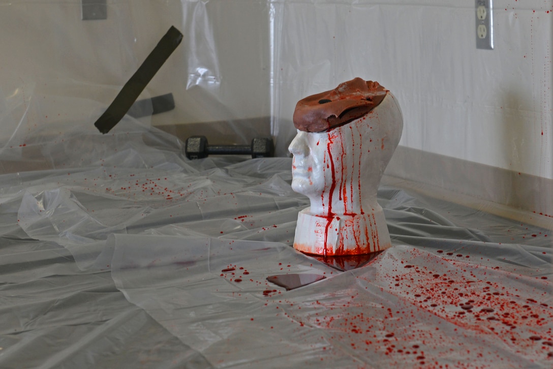 A replica head sits on the floor after being hit with a baseball bat and a gun several times to determine blood patterns after a forensic science demonstration at Shaw Air Force Base, S.C., March 28, 2017. Blood patterns can be used to determine the angles of and the number of attacks at a crime scene. (U.S. Air Force photo by Airman 1st Class Destinee Sweeney)