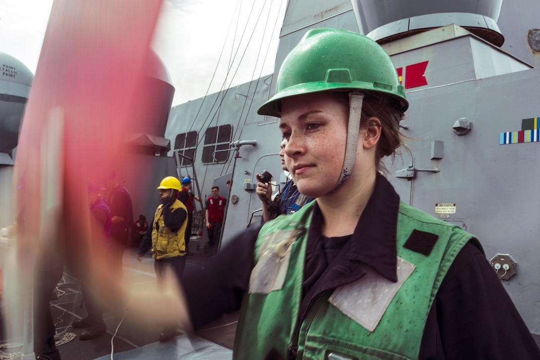 Navy Seaman Summer Hurley signals from the amphibious transport dock ship USS Green Bay to the Military Sealift Command dry cargo and ammunition ship USNS Richard E. Byrd during a replenishment-at-sea in the East China Sea, March 20, 2017. Green Bay, part of the Bonhomme Richard Expeditionary Strike Group, with the embarked 31st Marine Expeditionary Unit, is on a routine patrol operating in the Indo-Asia-Pacific region to enhance partnerships and be a ready-response force for any type of contingency. Navy photo by Petty Officer 2nd Class Kaleb R. Staples