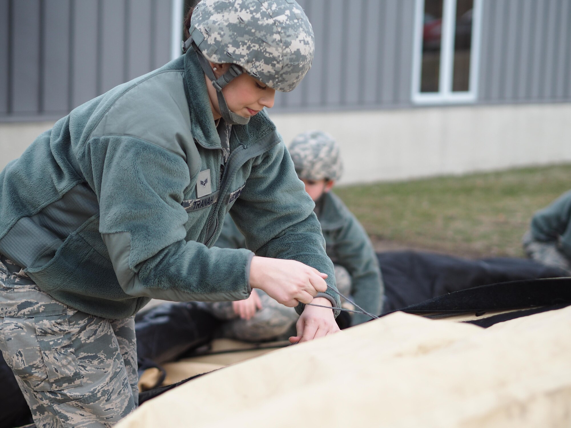 Senior airman Paige Tranah, 934th Force Support Squadron, attaches the SPEK kitchen tent to the frame.