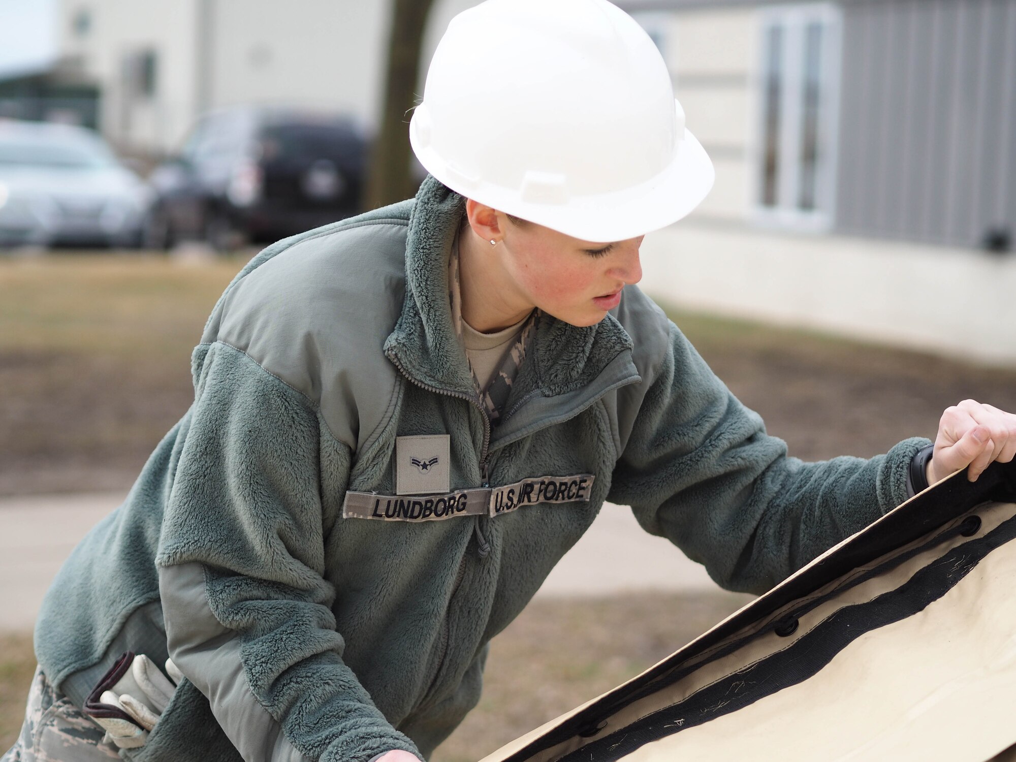 Airman 1st Class Madison Lundborg, 934th Force Support Squadron, moves the SPEK kitchen canopy into position on the frame.