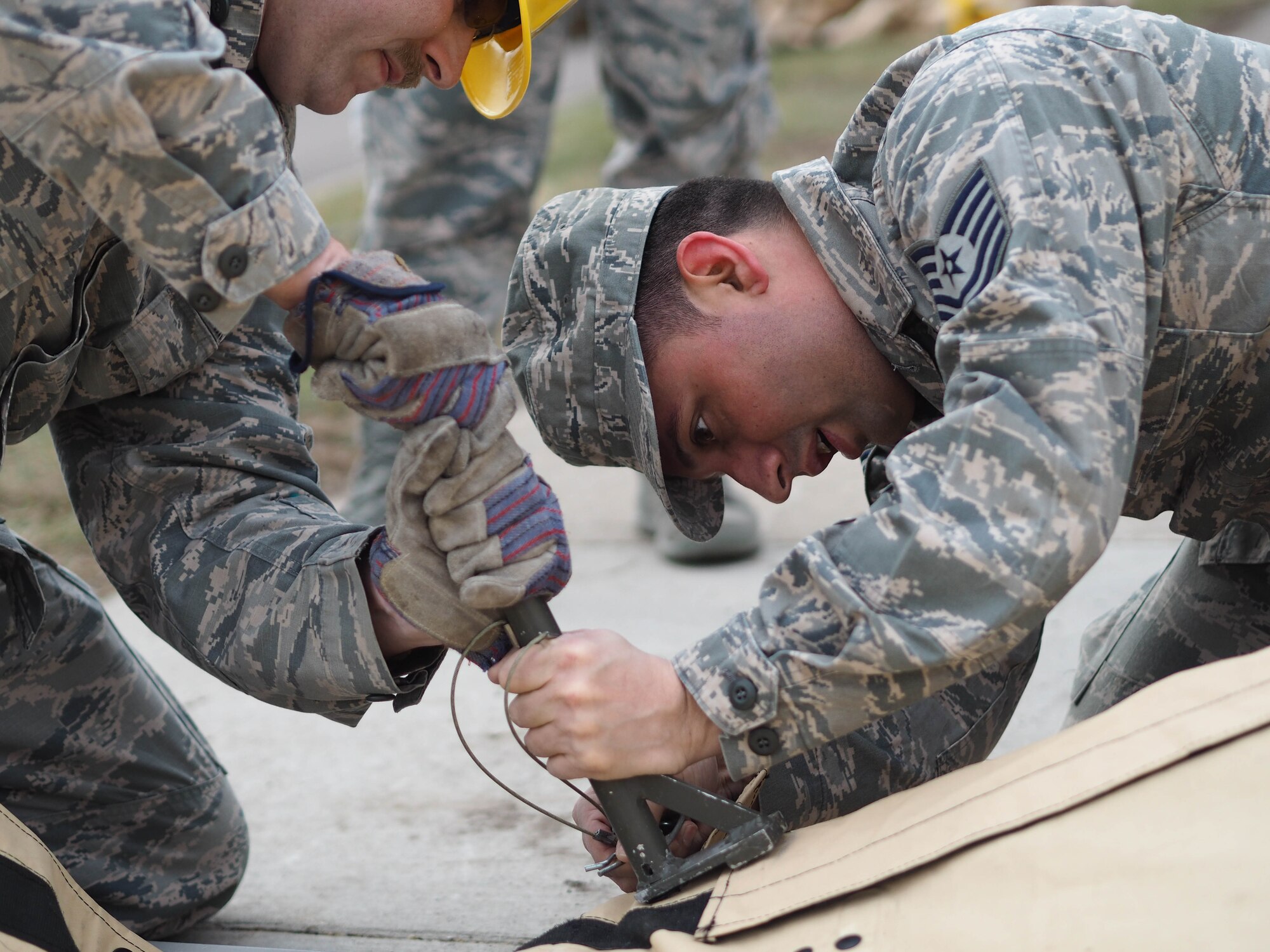 Tech. Sgt. Brandon Lancaster, 934th Force Support Squadron, anchors the SPEK kitchen frame to the ground.