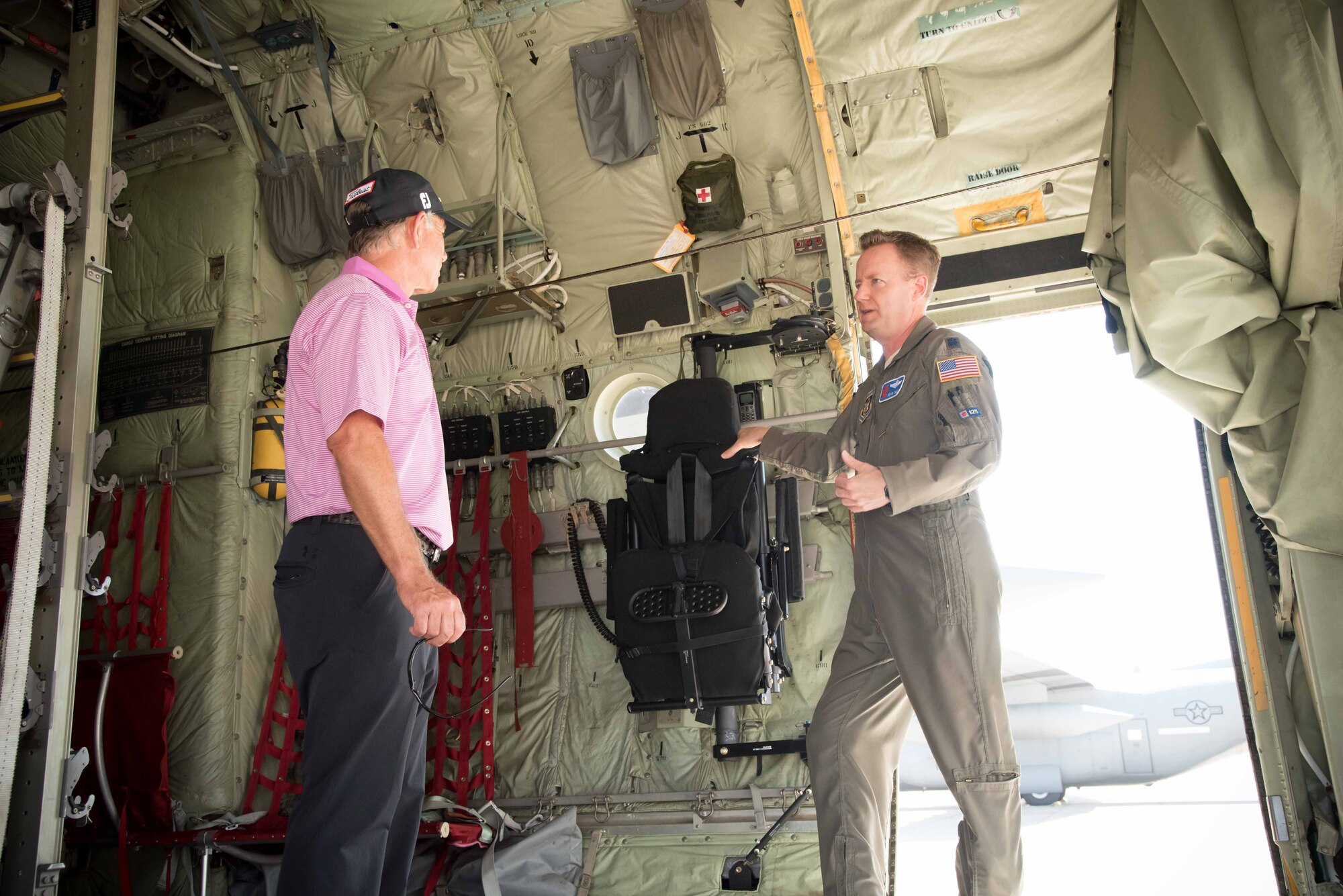 Lt. Col. Sean Cross, 53rd Weather Reconnaissance Squadron pilot, explains his squadron's mission and capabilities to Professional Golfers' Association golfer Mike Goodes March 29 at Keesler Air Force Base, Mississippi. (U.S. Air Force photo/Maj. Marnee A.C. Losurdo)