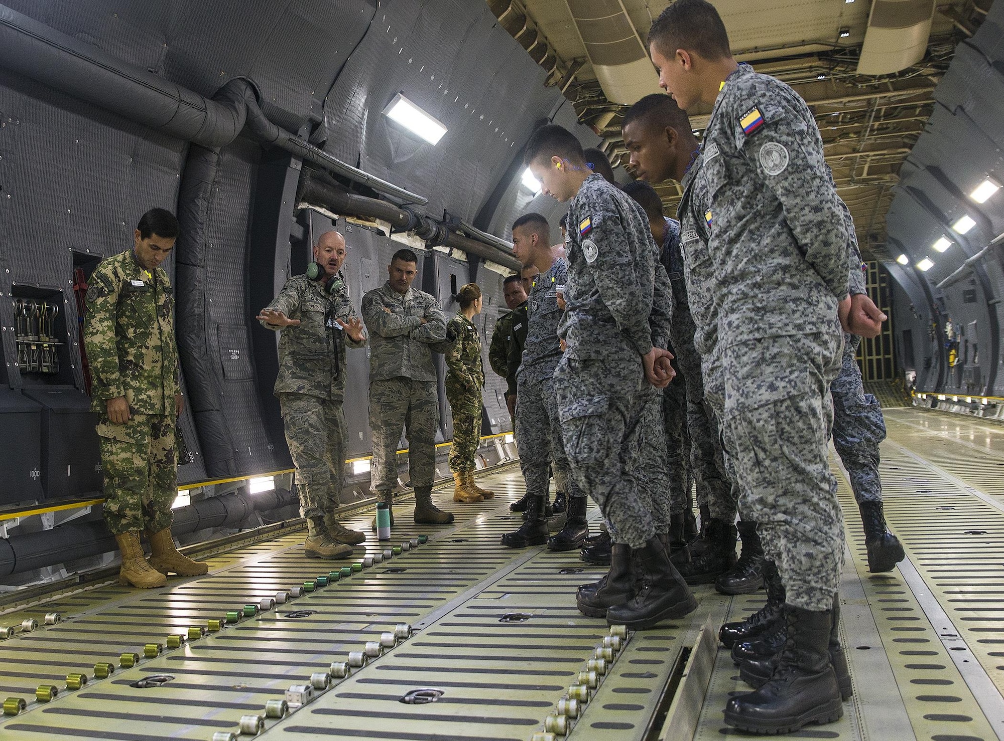 Senior Master Sgt. A. Clark, a 356th Airlift Squadron flight engineer, shows students from the  Inter-American Air Forces Academy how the rollers on the C-5M Super Galaxy aircraft are used to load cargo March 29, 2017 at Joint Base San Antonio-Lackland, Texas. As part of their tour the students also toured the structural, metals,  survival, and engine shops.  (U.S. Air Force photo by Benjamin Faske)