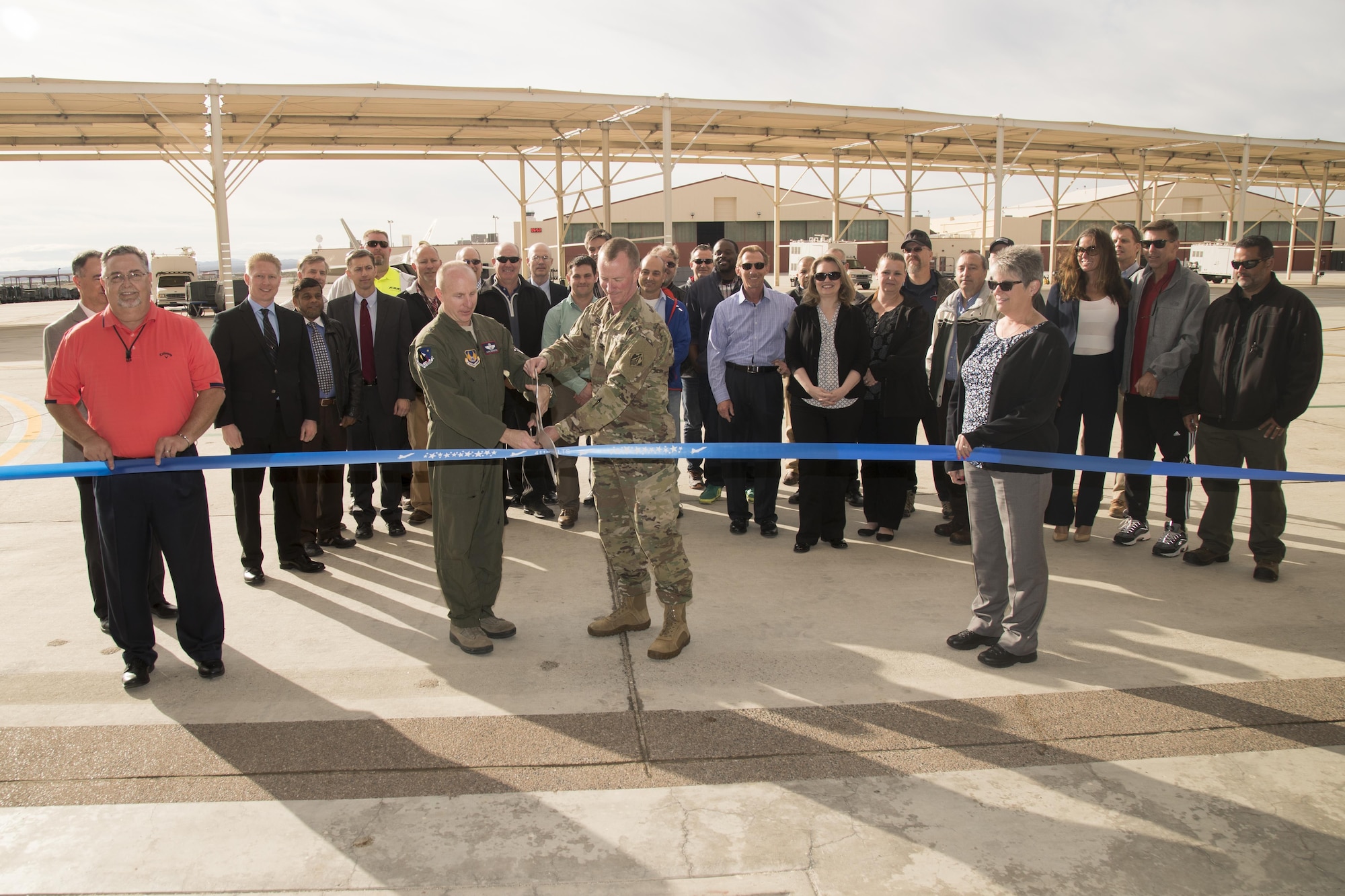 With scissors in hand, Brig. Gen. Carl Schaefer, 412th Test Wing commander (left, and Army Col. Kirk Gibbs, U.S. Army Corps of Engineers Los Angeles District commander, prepare to cut the ceremonial ribbon signifying the official opening of the new 411th Flight Test Squadron facility March 22. The squadron is responsible for the developmental testing of the F-22 Raptor and its systems. (U.S. Air Force photo by Christian Turner)