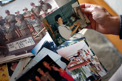 Iowa Army National Guard Chief Warrant Officer 5 Marty Hupp, of Grimes, Iowa, sorts through photographs from her 40-year military career in light of her upcoming retirement. 