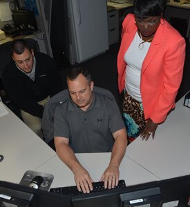 To better utilize the Air Force's top secret communications system, there is a migration taking place that will consolidate all legacy Air Force and Air National Guard JWICS, synchronizing JWICS Air Force wide. Melanie Weems, program manager, AF JWICS Program Management Office, works with multiple contract personnel, like Brian Boblett, migration specialist, and Russ Williamson, migration technician lead, to complete the migration. (U.S. Air Force photo by Lori A. Bultman)