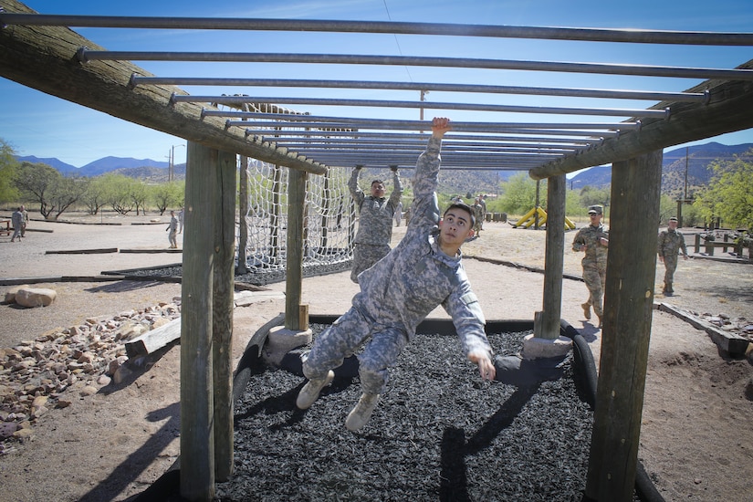 Army Reserve Spc. Julian Ditona (center), a multi-channel transmission systems operator/maintainer, assigned to the 98th Expeditionary Signal Battalion, 335th Signal Command (Theater), swings across an obstacle at the obstacle course challenge at Fort Huachuca, Arizona March 28. Ditona and seven other Soldiers are competing in the command’s 2017 Best Warrior Competition, in hopes of representing their unit at the U.S. Army Reserve Commands 2017 Best Warrior Competition later this year. (Official U.S. Army Reserve photo by Sgt. 1st Class Brent C. Powell)
