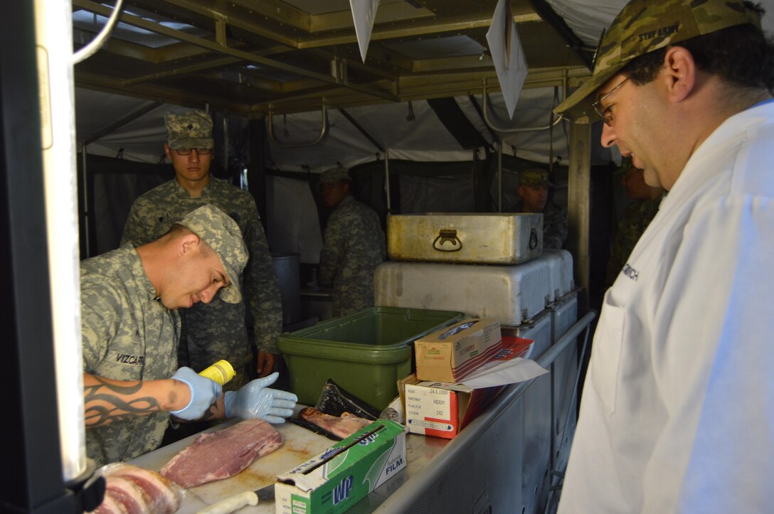 1002nd Quartermaster Company’s U.S. Army Reserve Cpl. Enrique Vizcarra, a culinary specialist, preps meat for cooking while evaluator Samuel Stanovich with the National Restaurant Association Military Foundation looks on during the Philip A. Connelly cooking competition held at Fort Polk, Louisiana, March 25, 2017. During the Philip A. Connelly Program, the U.S. Army Reserve partners with the National Restaurant Association to give food service personnel an opportunity to demonstrate their capability and combat-readiness while competing for recognition. (U.S. Army Reserve photo by Master Sgt. Dave Thompson)