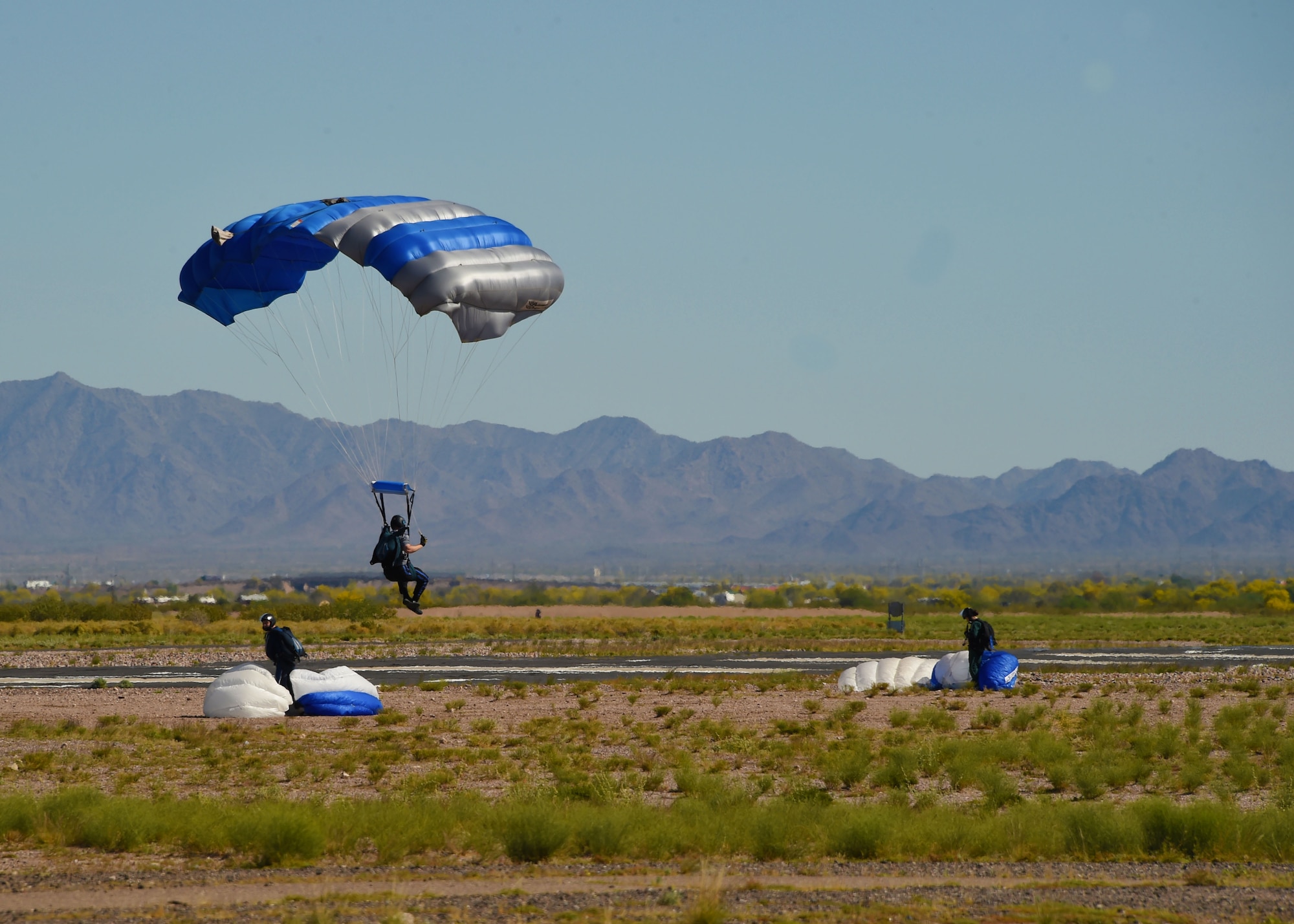 A cadet from the Wings of Blue Parachute Team prepares to land in a designated zone, March 29, 2017 at the Barry M. Goldwater Range in Gila Bend, Ariz. The Wings of Blue performs at Air Force events such as air shows and footballs games as well as select professional sporting events.  (U.S. Air Force photo by Airman 1st Class Caleb Worpel)