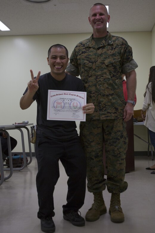 Hiroki Owan poses with Col. Kevin A. Norton, right, for a photo with Hiroki Owan during a ceremony March 29 aboard Camp Schwab, Okinawa, Japan. Owan is a student of the weekly adult English program who received a certificate of completion for attending a year of classes. Norton is the Camp Schwab camp commander. 