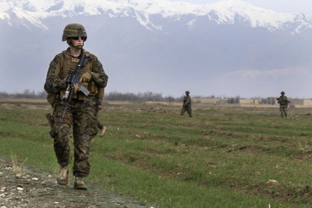 U.S Marine Corps Cpl. Bailey A. Hardiman patrols through a field with Czech and Afghan soldiers near Bagram Airfield, Afghanistan, March 24, 2017. Hardiman is a liaison officer assigned to the Georgian Liaison Team, Rotation Four. Hardiman is filling an infantry billet where she works as the liaison officer for the Czech military patrols. Army photo by Sgt. 1st Class LaSonya J. Johnson