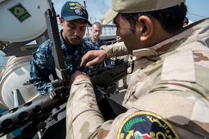 Gunner's Mate 2nd Class Gabriel Lewis discusses an m240 light machine gun’s operating procedures and techniques with an Iraqi sailor aboard the Iraqi Offshore Support Vessel Al Basra (OSV 401) during a trilateral exercise between the U.S., Kuwait and Iraqi armed forces in the Arabian Gulf, March 15, 2017. (U.S. Navy Combat Camera photo by Mass Communication Specialist 2nd Class Corbin J. Shea)