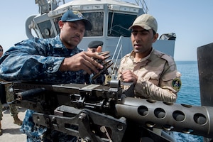 Gunner's Mate 2nd Class Gabriel Lewis discusses an m240 light machine gun’s operating procedures and techniques with an Iraqi sailor aboard the Iraqi Offshore Support Vessel Al Basra (OSV 401) during a trilateral exercise between the U.S., Kuwait and Iraqi armed forces in the Arabian Gulf, March 15, 2017. (U.S. Navy Combat Camera photo by Mass Communication 2nd Class Corbin J. Shea)