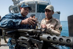 Gunner's Mate 2nd Class Gabriel Lewis discusses an m240 light machine gun’s operating procedures and techniques with an Iraqi sailor aboard the Iraqi Offshore Support Vessel Al Basra (OSV 401) during a trilateral exercise between the U.S., Kuwait and Iraqi armed forces in the Arabian Gulf, March 15, 2017. (U.S. Navy Combat Camera photo by Mass Communication 2nd Class Corbin J. Shea)