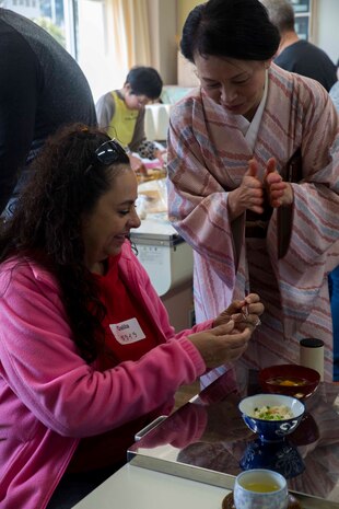 Dalila Garavito, a Marine Corps Air Station Iwakuni resident, learns how to use hashi (chop sticks) during the cultural exchange at Tsuzu Elementary School at Iwakuni City, Japan, March 11, 2017. During the event, a traditional tea ceremony was demonstrated and a cooking class was held to teach people how to make common Japanese dishes. The event taught residents from MCAS Iwakuni about Japanese culture, which brought Americans and Japanese together. (U.S. Marine Corps photo by Lance Cpl. Gabriela Garcia-Herrera)