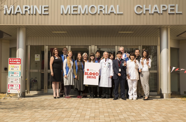 The Marine Corps Air Station Iwakuni Red Cross Society and Japanese Red Cross Society volunteers pose in front of the Marine Memorial Chapel during a blood drive at MCAS Iwakuni, Japan, March 7, 2017. The volunteers collaborated together and collected approximately 24,000 milliliters of blood from 59 Japanese and American donors. (U.S. Marine Corps photo by Pfc. Stephen Campbell)