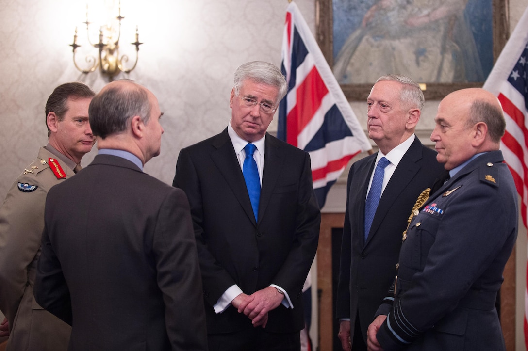 Defense Secretary Jim Mattis speaks with British Defense Secretary Michael Fallon, center, before an arrival ceremony at Britain's Defense Ministry in London.