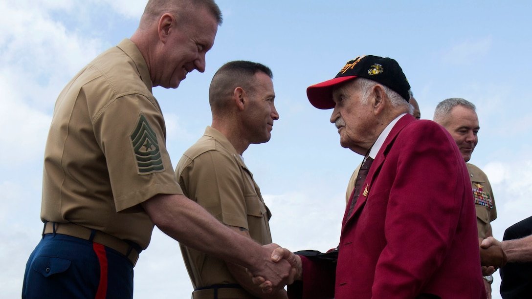 Iwo Jima veteran George Cattalona is greeted by senior enlisted and officers at the 72nd Reunion of Honor commemorative service on Iwo To, Japan March 25, 2017. Cattalona was one of eight veterans in attendance alongside American and Japanese distinguished guests, both military and civilian. This event presented the opportunity for the U.S. and Japanese people to mutually remember and honor thousands of service members who fought and died on the hallowed grounds of Iwo Jima.