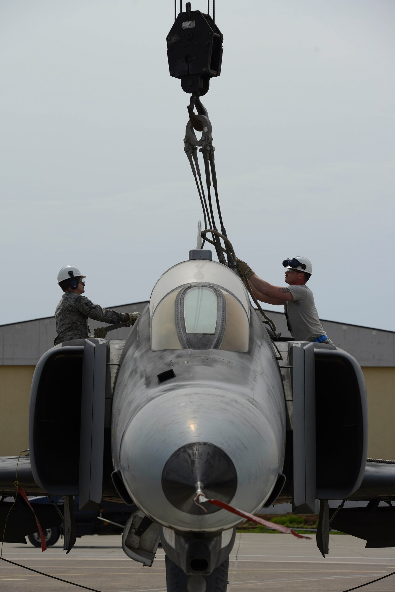 U.S. Air Force Staff Sgt. Corey Nickles (left), and Senior Airman Chadon Bowman, both 39th Maintenance Squadron transient alert, Crash Damaged Disabled Aircraft Recovery (CDDAR) team members, work together to attach a crane to a decommissioned Turkish air force F-4 Phantom March 30, 2017, at Incirlik Air Base, Turkey. 39th MXS Airmen worked closely with their Turkish air force counterparts to coordinate this training opportunity. The primary objective of the CDDAR mission is to quickly and safely remove immobile aircraft and return the runway to operational status. (U.S. Air Force photo by Airman 1st Class Devin M. Rumbaugh)