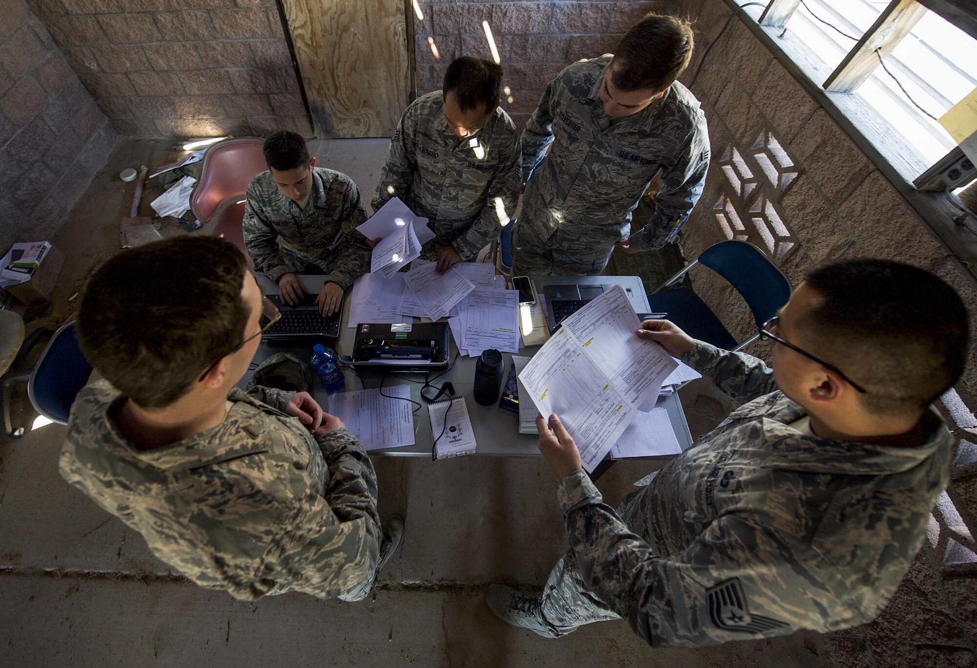 A team of U.S. Air Force contracting officers review offers after meeting with simulated vendors during a training exercise organized by the 99th Contracting Squadron on Nellis Air Force Base, Nev., March 16, 2017. The exercise was spread over two days, one day for lectures and scenarios followed by one day in the field with the challenges of a bare base environment. (U.S. Air Force photo by Airman 1st Class Kevin Tanenbaum/Released)