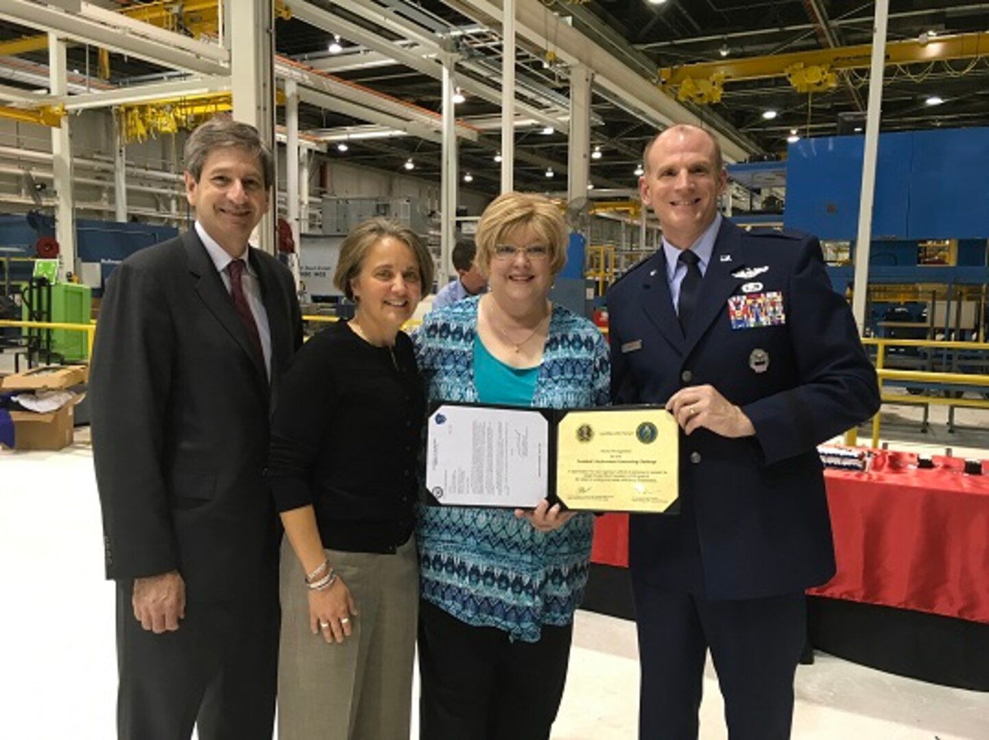 (second from right) Following the ceremony DLA Energy Contracting Officer Cynthia Obermeyer was presented with a letter of congratulations along with the White House Council on Environmental Quality and Department of Energy Federal Energy Management Program Directors’ Award Recognition for her overall support of the Presidential Performance Contracting Challenge and the significant contributions this project effort makes toward conserving our nation’s energy and water resources. Standing with her are Deputy Assistant Secretary of the Air Force for Environment, Safety, and Infrastructure Mark Correll (left), DLA Energy Installation Energy Director Pam Griffith (second to left) and DLA Energy Commander Brig. Gen. Martin Chapin (right). 