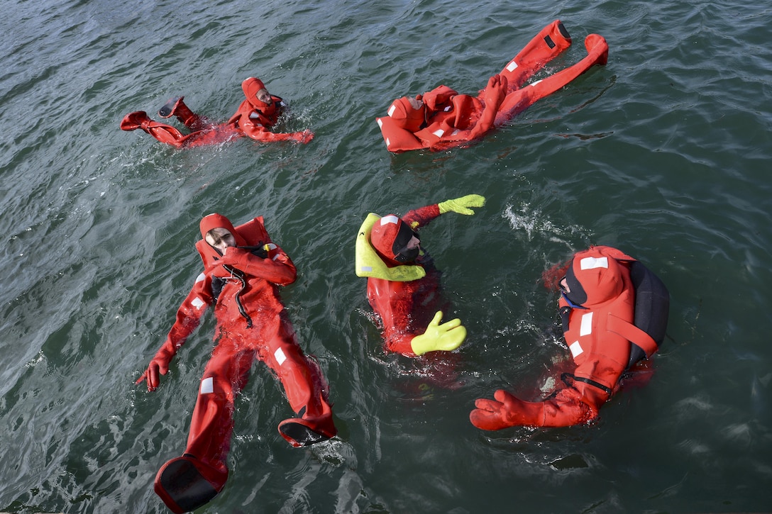 Mike Rudolph, a Coast Guard fishing vessel safety examiner, teaches students how to move around more efficiently in survival suits during an 18-hour drill conductor's course in Newport, Ore., Mar. 24, 2017. Coast Guard photo by Petty Officer 1st Class Zac Crawford