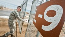 Airman 1st Class Heath Rauch, 91st Missile Maintenance Squadron electromechanical team technician, closes a launch facility gate near Bowbells, N.D., March 29, 2017. Rauch was a part of a two-man team responsible for draining flood-water from LFs across the missile complex. (U.S Air Force photo/Senior Airman J.T. Armstrong)