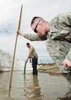 (From right) Airman 1st Class Heath Rauch and Senior Airman Matthew Singer, 91st Missile Maintenance Squadron electromechanical team technicians, measures and remove flood-water near Bowbells, N.D., March 29, 2017. Rauch and Singer worked with to drain water to a safe level. (U.S Air Force photo/Senior Airman J.T. Armstrong)