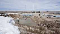 Airmen from the 91st Missile Maintenance Squadron drain flood-water from a launch facility near Bowbells, N.D., March 29, 2017. The electromechanical team technicians measured rising water levels and relocated water, snow and mud away from critical 91st MW assets. (U.S Air Force photo/Senior Airman J.T. Armstrong)