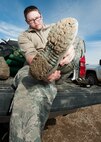 Senior Airman Matthew Singer, 91st Missile Maintenance Squadron electromechanical team technician, removes his boot at a launch facility near Bowbells, N.D., March 29, 2017. Singer was a part of a two-man team responsible for relocating flood-water away from critical assets at the launch facility. (U.S Air Force photo/Senior Airman J.T. Armstrong)