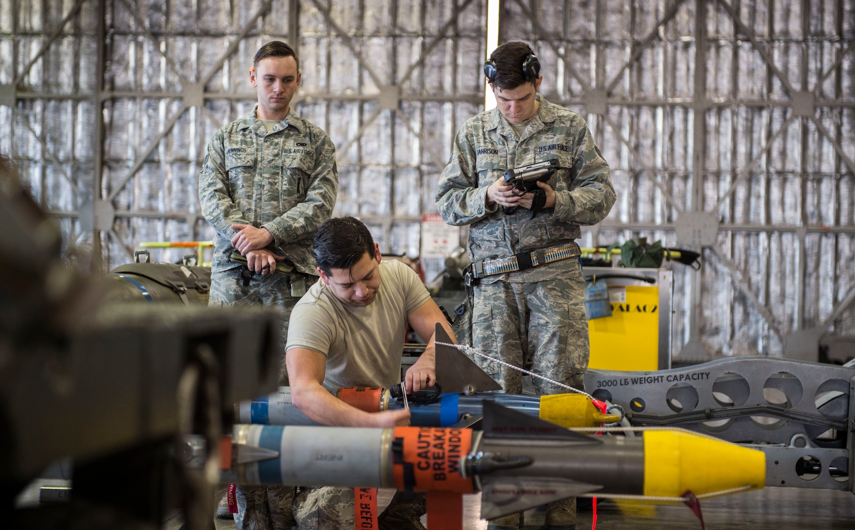 U.S. Air Force Senior Airman Jacob D. Jennings, left, a 35th Maintenance Group weapons evaluator, watches Senior Airman Paul Uribe, center, a 13th Aircraft Maintenance Squadron load crew member prepare an AIM-9 sidewinder as Staff Sgt. Daniel Garrison, right, a 13th Aircraft Maintenance Squadron weapons load crew team chief, reviews checklist at Misawa Air Base, Japan, Feb. 28, 2017. Misawa displays its commitment to the Indo-Asia-Pacific by ensuring its Airmen stay ready each day to perform their critical duties, in this case loading weapons onto F-16 Fighting Falcons.