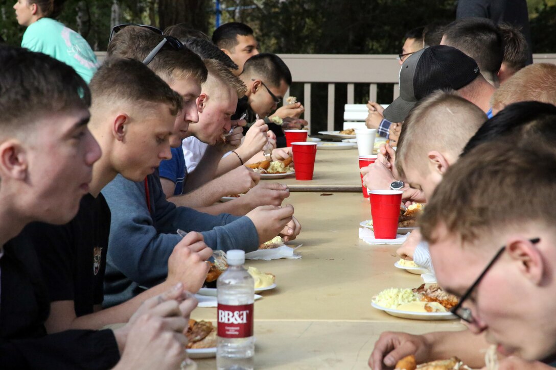 Marines and their families gather and eat food at the annual Pig Pickin’, sponsored by the Havelock Military Affairs Committee at Marine Corps Air Station Cherry Point, March 30, 2017. More than 200 people, including Marines with Marine Attack Training Squadron 203, Marine Aircraft Group 14, 2nd Marine Aircraft Wing, family members and members of the Havelock community attended the event. The Havelock MAC started the Pig Pickin’ tradition in 1992 as a way to show community support of service members on the air station, increase unit morale, and reconnect Marines with their families. (U.S. Marine Corps photo by Cpl. Mackenzie Gibson/ Released)
