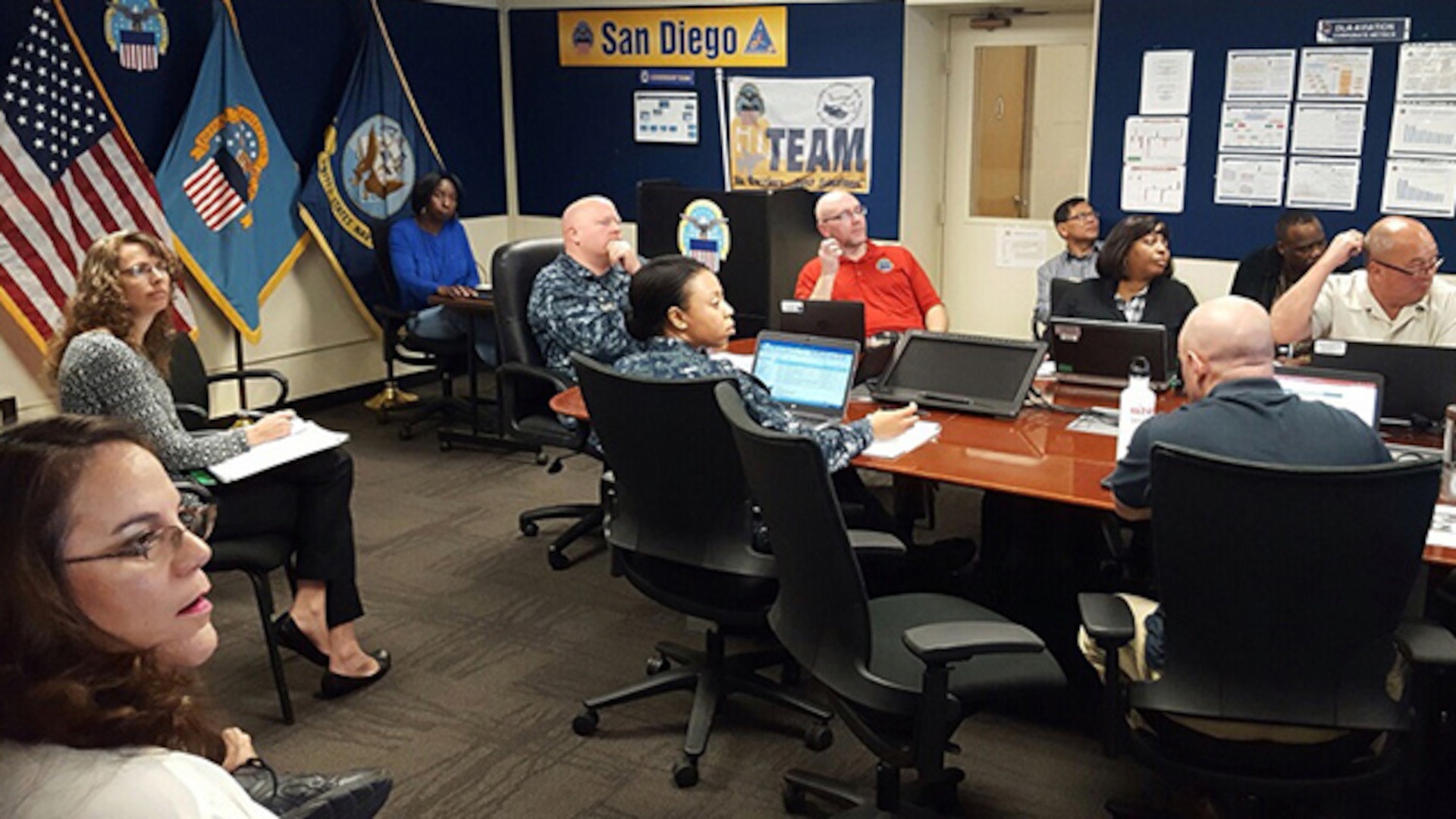 Defense Logistics Agency Aviation's commander hosts monthly retail governance board teleconferences with DLA Aviation employees and contractors at the fleet readiness centers at San Diego, California, Cherry Point, North Carolina, and at Jacksonville, Florida.  San Diego employees are shown receiving metrics updates and the newly established deputy material management chief (military) in San Diego currently held by Navy Lt. J.G. Angeli LeGardye, center, fills one of three positions being established at the FRC’s, to team up with industry partners and assist in solving difficult material readiness challenges.