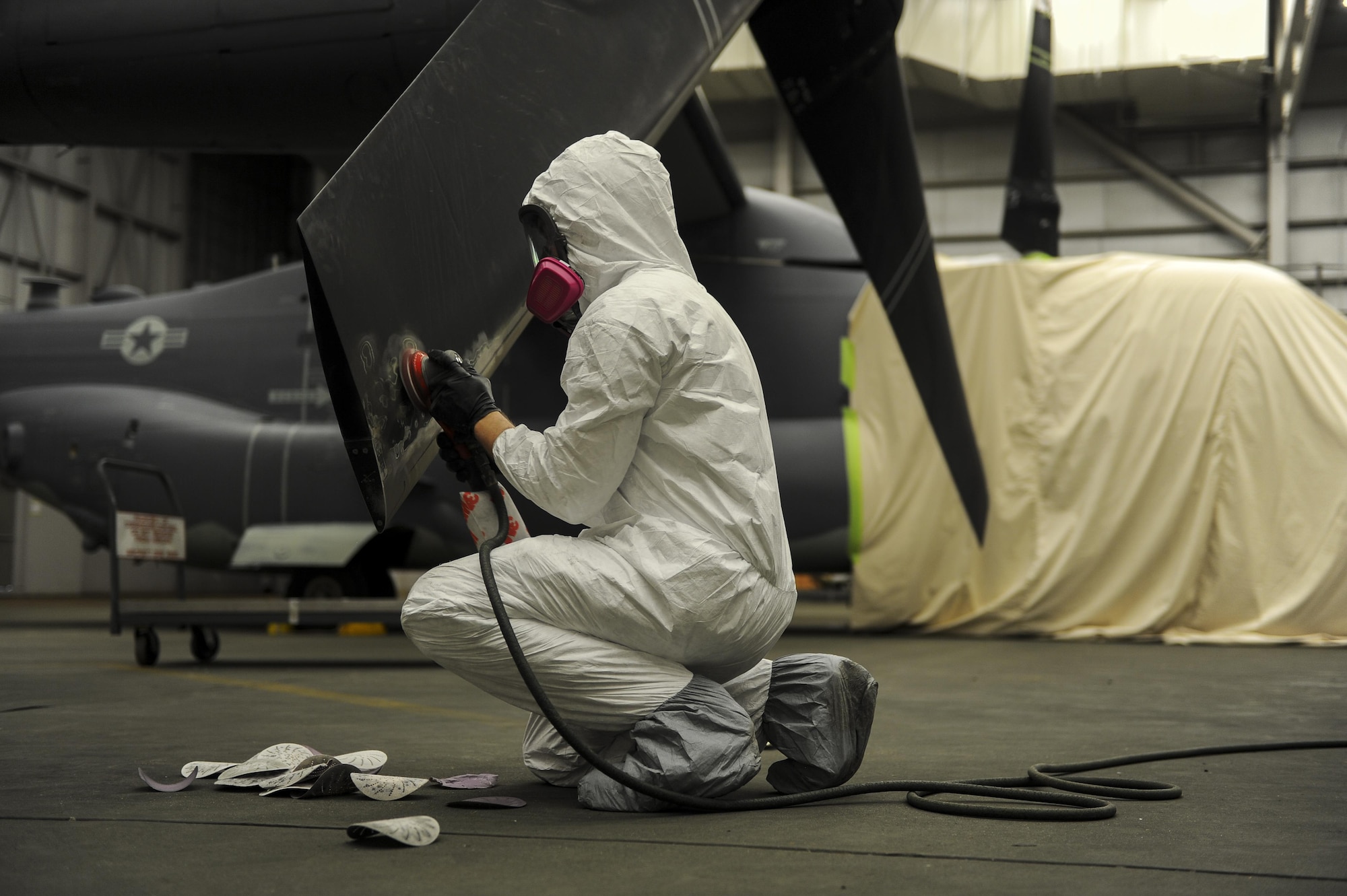 Airman 1st Class Ethan Short, an aircraft structural maintainer with the 1st Special Operations Maintenance Squadron, sands down a propeller to remove paint from a CV-22 Osprey at Hurlburt Field, Fla., March 28, 2017. Sanding down the equipment is the first step in a several day process to ensure the new primer and paint adhere to the surface of the aircraft. (U.S. Air Force photo by Airman 1st Class Isaac O. Guest IV)