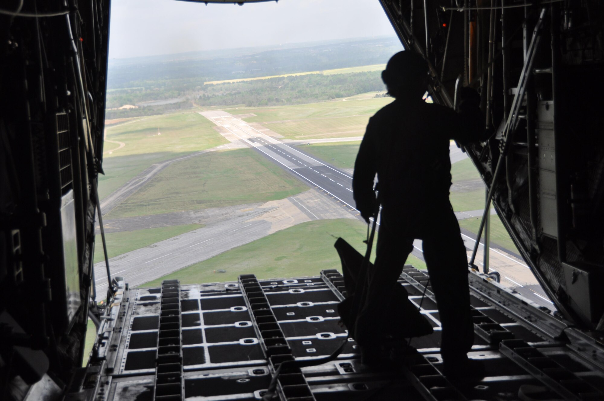 Senior Master Sgt. Chris Brown, a C-130 Hercules loadmaster with the 908th Airlift Wing recovers a parachute bag, seconds after a Containerized Delivery System Bundle was dropped from the aircraft over Maxwell Air Force Base March 28. The drop was done in preparation for the Maxwell Air Show coming up April 8 and 9. (U.S. Air Force photo by Bradley J. Clark)