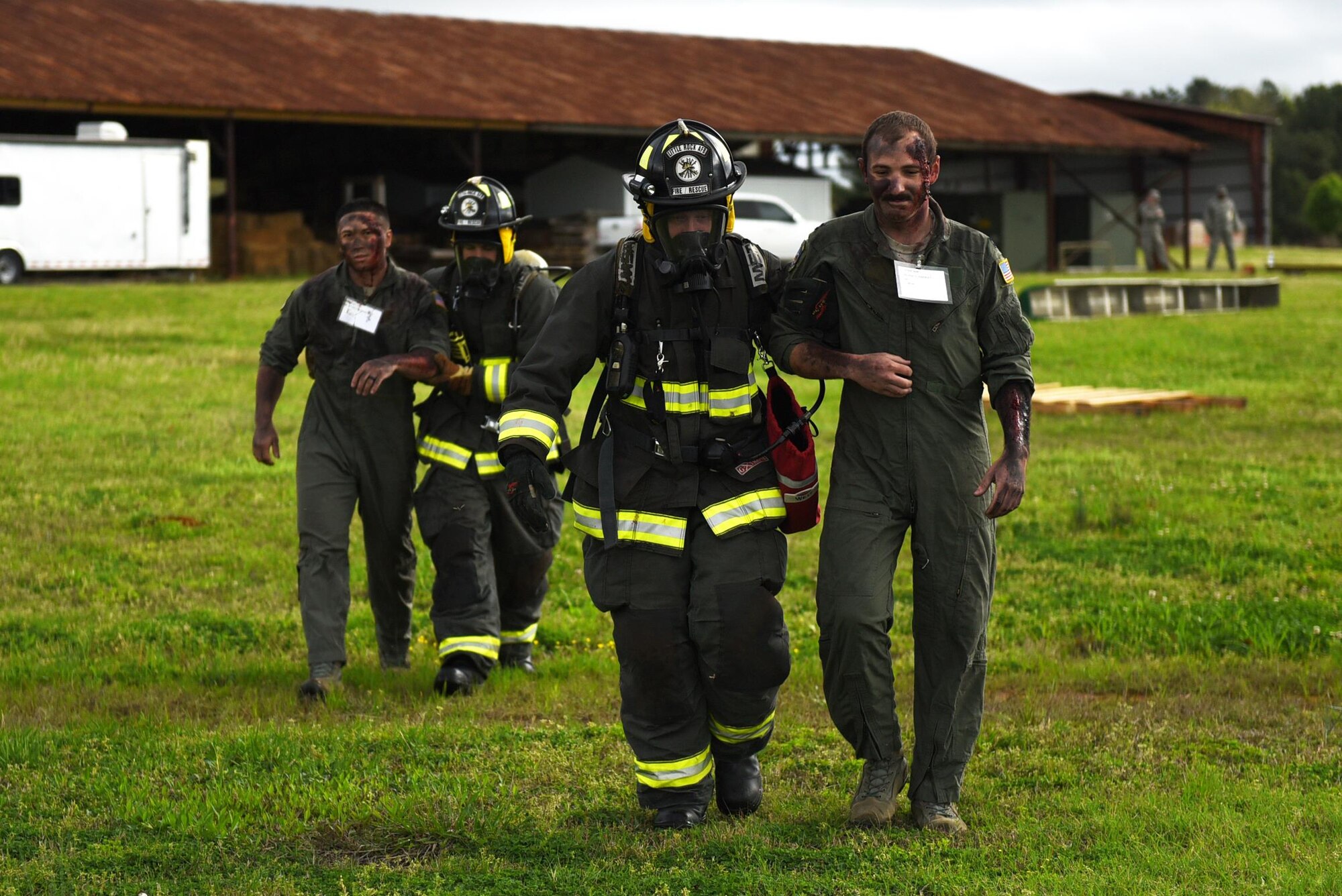 U.S. Air Force Senior Airman Lance Hendricks and U.S. Air Force Michael Leger, 19th Civil Engineer Squadron Fire Department firefighters, escort simulated crash victims to safety during a major accident response inspection March 30, 2017, at the Jacksonville Fire Department Training Center, Ark. Aircraft parts and simulated flare shells were arranged to replicate debris. (U.S. Air Force photo by Airman 1st Class Kevin Sommer Giron)