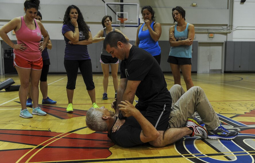 Maj. Dan Griffin, an executive officer with Air Force Special Operations Command, simulates choking Michael “Moose” Moore, founder of The Vigilance Group, during a demonstration in front of Air Commando spouses at Hurlburt Field, Fla., March 31, 2017. This training provides techniques to avoid danger and actions to take if violence is not preventable. (U.S. Air Force photo by Airman 1st Class Isaac O. Guest IV)