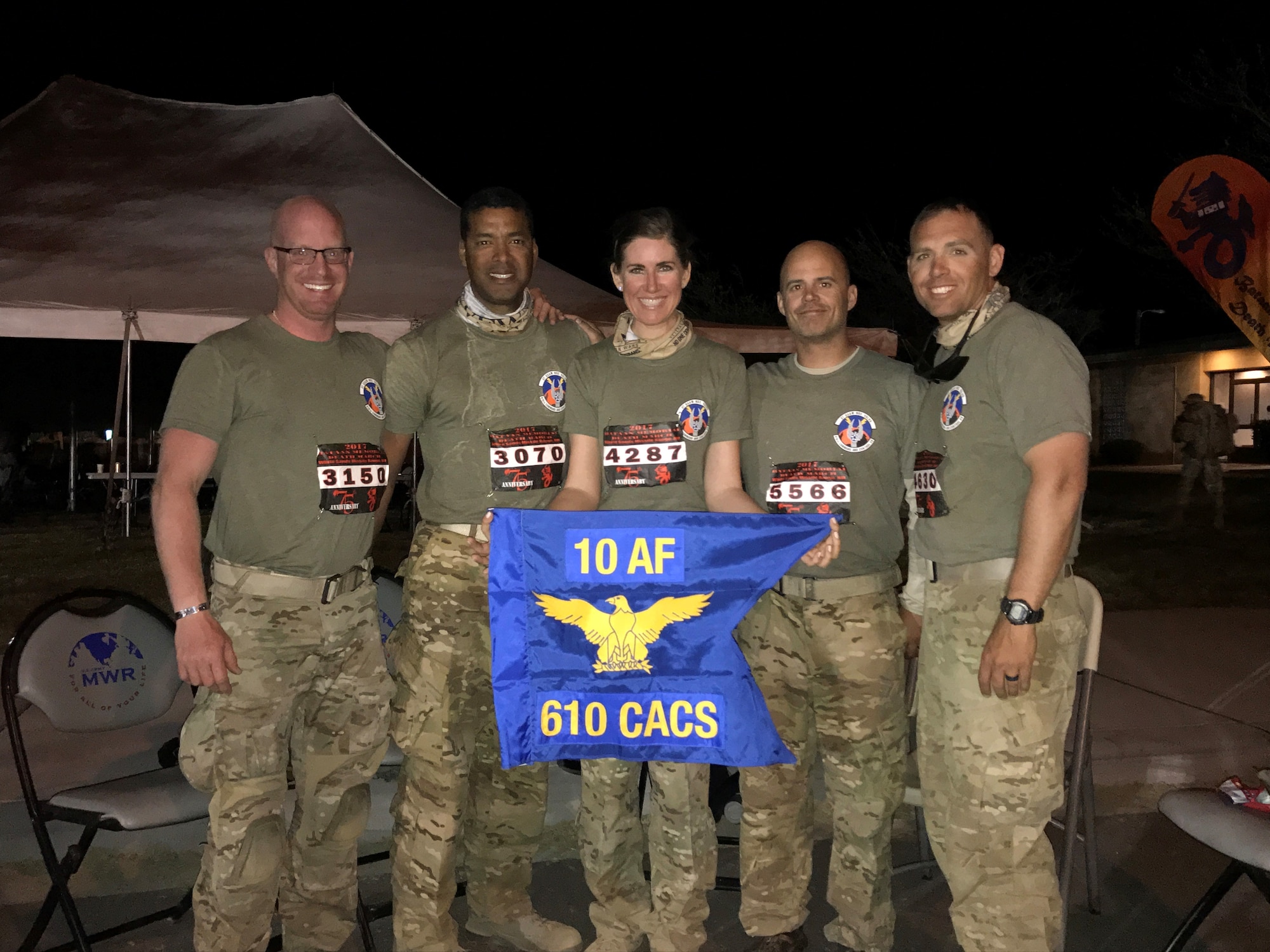 (Left to Right) U.S. Air Force Reservists, Master Sgt. John Herrick, 39, who has completed three other marathons; Staff Sgt. Tyrone Hawkins, 47, an avid cyclist; 2nd Lt. Amber Schoenberger, a direct descendent of a Bataan Death March survivor; Tech. Sgt. Delbert Templeton, 36, a prior Marine; and Tech. Sgt. Trevor Petersma, 39, who completed the Air Force half marathon while deployed in Iraq in 2008, all members of the 610th Command and Control Squadron, pose behind their unit guidon after completing the Bataan Memorial Death March Marathon March 19 at White Sands Missile Range, NM. (Courtesy photo)