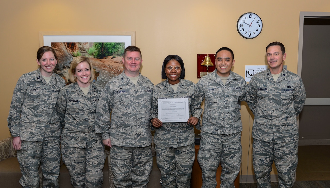 1st Lt. Tyesha McBride, 99th Mission Support Group executive officer, is presented with a certificate of achievement for completing her cancer treatment on March 21, 2017, in the Mike O’Callaghan Medical Center at Nellis Air Force Base, Nev. McBride was diagnosed with Hodgkin's lymphoma which is a cancer of the lymphatic system. (U.S. Air Force photo by Airman 1st Class Nathan Byrnes)
