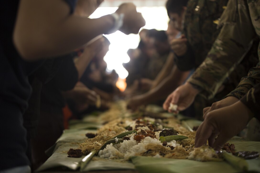 Philippine and U.S. service members participate in a Boodle Fight after a Tactical Combat Casualty Care class at Camp General Ceferino S. Carreon in Calinog, Iloilo, April 27, 2017. A Boodle Fight is a Filipino military tradition to symbolize brotherhood and camaraderie. Balikatan is an annual U.S.-Philippine military bilateral exercise focused on a variety of missions, including humanitarian assistance and disaster relief, counterterrorism, and other combined military operations. 